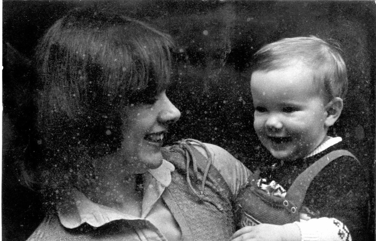 A damaged black and white photograph of a mother and child